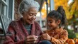 © Thanyaporn - Bonding Through Yarn: Senior Woman Teaches Granddaughter Knitting on Porch