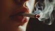 © Suphawan - Close-up of a lit cigarette between someones lips, smoke curling around their face as they inhale, focusing on the cigarette and smoke.