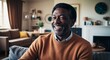 © Arceli - Happy middleaged Black man wearing a sweater in a cozy family room