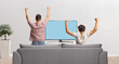 © Ljupco Smokovski - Rear view shot of a father and child cheering in front of tv