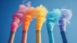 © sunchai - Colorful smoke rising from industrial chimneys against a blue sky.