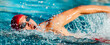 © Maridav - Swimming. Swim competition swimmer athlete doing crawl stroke in swimming pool. Sports man male swimmer with goggles and cap breathing racing in indoor stadium. Speed exercise workout.