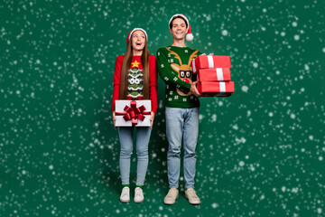 Poster - Photo of excited dream couple hold pile gifts enjoy party x-mas wear ugly sweater isolated green color background