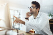© BestCam/peopleimages.com - Businessman, smile and pointing on computer on phone call for communication and networking. Male person, employee and happy with reading on website for discussion or conversation on research results