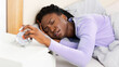 © Prostock-studio - Sleepy Black Girl Turning Off The Alarm Clock Lying In Bed At Home In The Morning. Selective Focus