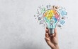 © Maryono - Hand holding a colorful lightbulb with creative drawings around it