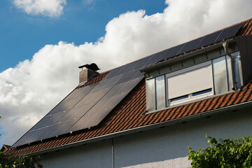 Black solar panels on a red tile roof