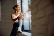 © Drazen - Smiling athletic woman day dreaming by  window.