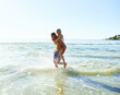 © StarDweller/peopleimages.com - Piggyback, couple and happy on ocean mockup for fun, excited and love on island adventure. Man, woman and carry in water space for support, travel and trust in relationship with vacation in Bali