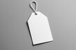 © InfiniteStudio - Minimalist mockup of a white paper hang tag against a smooth gray background, ideal for branding and product labeling