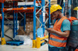 © Zamrznuti tonovi - African american male warehouse worker using smartphone during break time.
