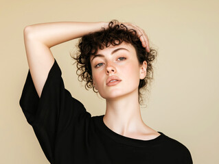 Natural portrait of a confident woman with curly hair in a relaxed pose, wearing a black shirt