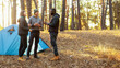 © Prostock-studio - Young multiethnic friends hikers camping in forest, talking next to tent and fireplace, copy space