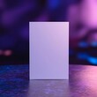 © atar - Blank white box mockup on a reflective surface with purple and blue neon lights in the background.
