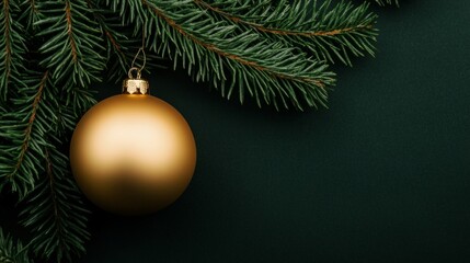 matte gold christmas ornament resting on lush green pine branches.