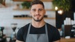 © top images - A man with a black shirt and apron is smiling for the camera