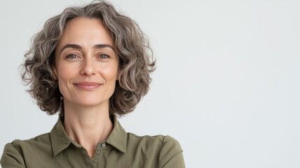 Canvas Print - A woman with a green shirt and gray hair is smiling