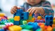 © Jojo* - Child's Hands Building with Colorful Plastic Blocks