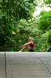 © Tirso Lecointere - Beautiful portrait of latin hispanic woman resting in sportwear sitting in a bridge in a public park after practicing yoga or workout. Freshness and sport concept.