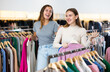 © JackF - Two happy female friends are shopping in a clothing store. Shopping young ladies