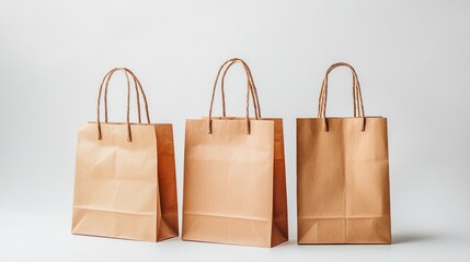 Three paper shopping bags with handles, displayed neatly on a crisp white backdrop