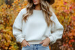 © Phichitpon - Portrait of a young woman wearing a crewneck white mockup sweatshirt with fall colors and themed background for autumn season female fashion