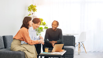 Poster - Multinational people talking while looking at a laptop in a lobby