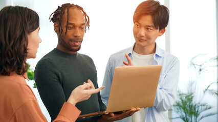 Poster - Multinational people in casual wear having a meeting about business management while looking at a laptop in an office