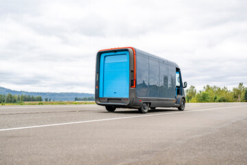 Electrical  cargo mini van making local deliveries running on the road going to to next delivery address