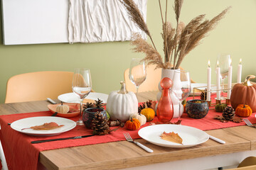 Wall Mural - Autumn table setting with pumpkins, dry leaves and burning candles in dining room