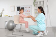 © Pixel-Shot - Female osteopath with little patient doing exercises in clinic
