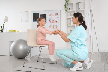 Wall Mural - Female osteopath with little patient doing exercises in clinic