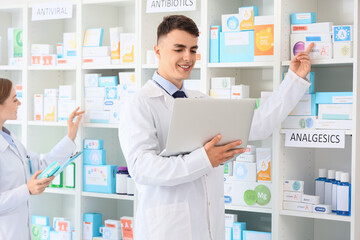 Sticker - Male pharmacist with laptop showing medications online at pharmacy