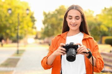 Wall Mural - Young female photographer with modern camera in park