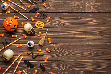 Sticker - Halloween composition with decor and candies on brown wooden background