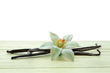 Wall Mural - Aromatic vanilla pods and flower on table against white background