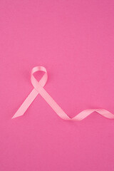 pink ribbon on a vibrant pink background symbolizes breast cancer awareness and support efforts