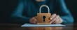 © Thann - A hand reaching towards a secure digital lock hovering over an insurance document on a minimalist office desk. Minimalistic, peaceful. Realistic, close-up shot with room for text.
