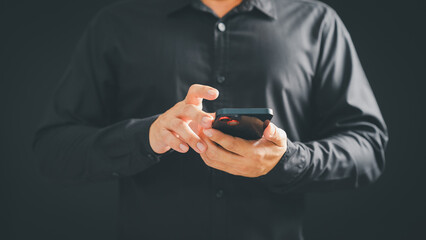 Person uses a smartphone, wearing a black shirt. The image highlights mobile technology, communication, and the ease of staying connected in a professional or casual setting.