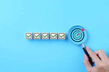 business strategy planning and quality management concept. magnifying glass focuses on target icon a