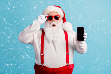 Poster - Portrait of his he nice attractive amazed white-haired Santa holding in hand device order shop app 5g fast speed service pout lips isolated bright vivid shine vibrant blue color background