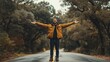 © fotofabrika - A joyful man stands with open arms in the middle of a serene, tree-lined road during a calm autumn day