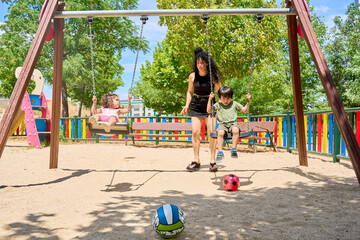 family having fun in the park on the swing set