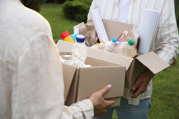 Wall Mural - Recycling. People holding cardboard boxes with different garbage outdoors, closeup