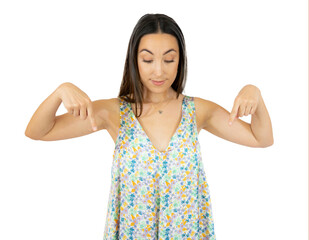 Young natural caucasian woman points down with fingers, positive feeling over transparent background.