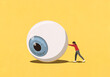 © fStop - Woman pushing large eyeball on yellow background