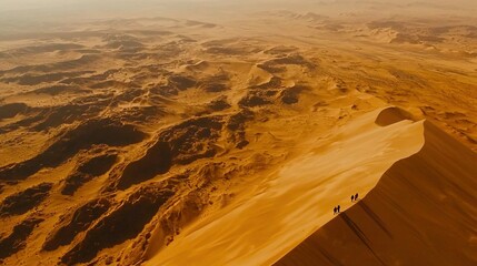 Wall Mural -   A group of individuals stands atop a sand dune amidst the desert landscape, surrounded by towering mountain ranges