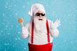 © deagreez - Photo of pensioner old fat man grey beard hold body brush prepare scratch have funny relaxation wear santa x-mas costume towel turban suspender sunglass isolated blue color background