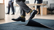 © Michaelyo - A Pair of Legs Tripping Over a Loose Carpet Edge, Capturing the Moment of an Office Stumble
