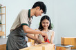 © itchaznong - Young Entrepreneurs Packing Boxes for Online Business in a Modern Home Office Setting